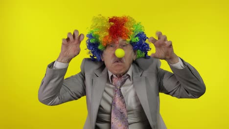 Senior-clown-businessman-entrepreneur-boss-making-silly-faces.-Yellow-background
