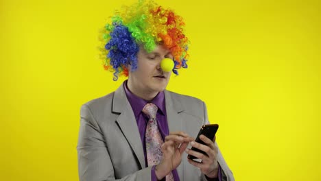 Clown-Geschäftsmann-Unternehmer-Chef-Erhält-Geldeinkommen,-Während-Er-Sein-Smartphone-Nutzt
