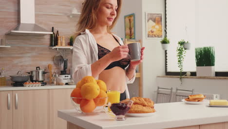 Attractive-woman-waking-up-with-fresh-cup-of-coffee