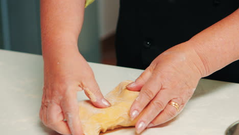 Woman-hands-taking-a-large-piece-of-dough