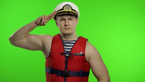 Muscular-sailor-man-works-as-lifeguard-at-beach-salutes-with-hand-to-camera