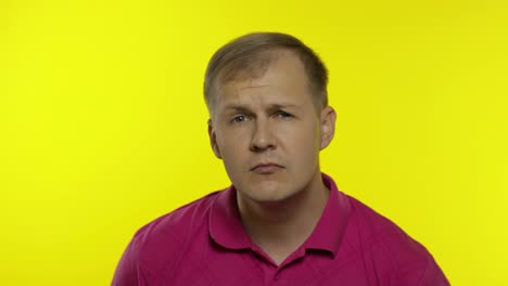 Portrait-of-young-caucasian-man-posing-in-pink-t-shirt.-Dissatisfied,-picky-guy-looking-to-camera