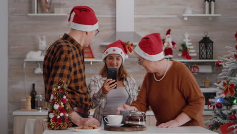 Grandparents-with-granddaughter-greeting-remote-mother-celebrating-xmas-holiday