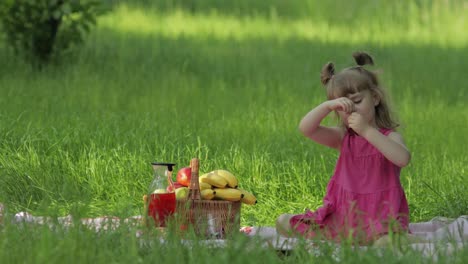 Wochenende-Beim-Picknick.-Schönes-Kaukasisches-Kindermädchen-Auf-Der-Wiese-Mit-Grünem-Gras,-Das-Fröhlich-Isst,-Kirsche