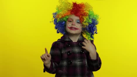 Little-child-girl-clown-in-colorful-wig-making-silly-faces.-Having-fun,-shows-tricks.-Halloween