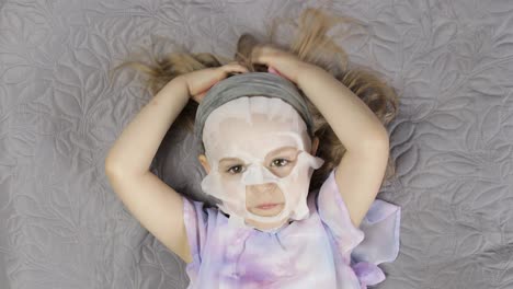 Teenager-Mädchen-Mit-Feuchtigkeitsspendender-Gesichtsmaske.-Kind-Kümmert-Sich-Um-Die-Haut-Mit-Kosmetischer-Gesichtsmaske