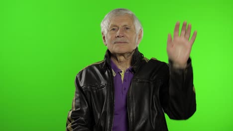 Elderly-caucasian-grandfather-rocker-and-biker-man-waves-his-hands,-greets