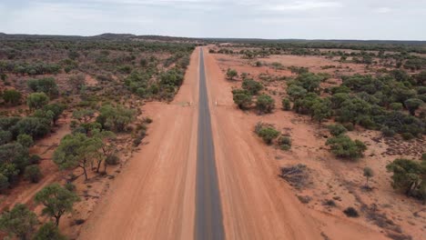 Drohne-Steigt-über-Einer-Sehr-Engen-Landstraße-Im-Australischen-Outback-Auf