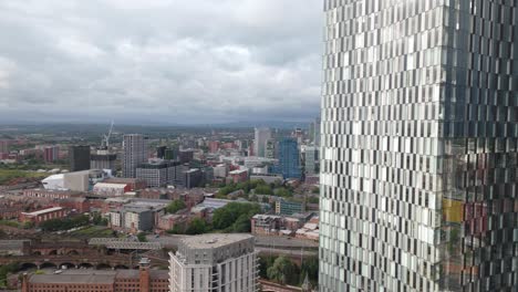 Establishing-aerial-view-Manchester-Deansgate-modern-city-centre-skyscraper-overlooking-downtown-district-skyline