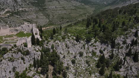 Eine-Luftaufnahme-Zeigt-Die-Festung-Blagaj-Auf-Dem-Karsthügel-In-Mostar,-Bosnien,-Die-Lodge-Ist-Von-Der-Burg-Auf-Dem-Gipfel-Des-Berges-Aus-Zu-Sehen