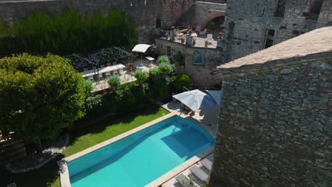 Aerial-view-over-luxurious-garden-with-swimming-pool-inside-the-medieval-renovated-castle-in-France
