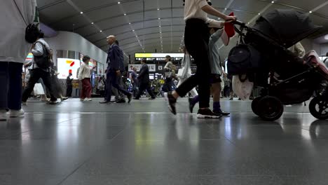 Tiefansicht-Der-Belebten-Bahnhofshalle-Von-Kyoto-Mit-Menschen,-Die-Mit-Gepäck-Vorbeigehen
