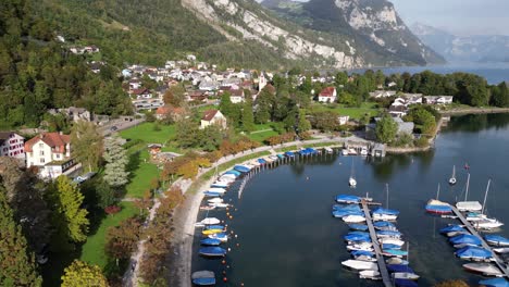 Luftaufnahmen-Des-Sees-Mit-Wassersport-Und-Vielen-Booten-In-Einer-Stadt-Im-Tal-Zwischen-Den-Bergen