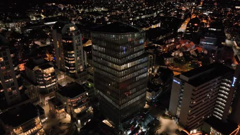 Aerial-View-of-K8-Tower-at-Night-in-Center-of-Stavanger,-Norway,-Modern-Office-Building-and-Downtown-in-Lights