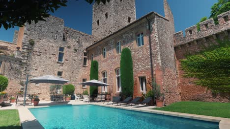 Swimming-pool-area-in-garden-of-a-french-castle,-tilt-shot-during-a-sunny-day