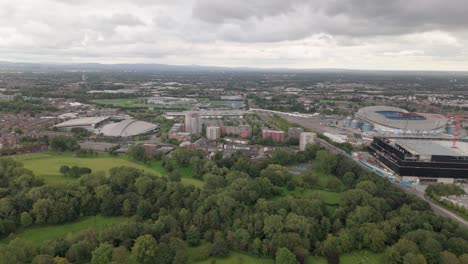 Aerial-over-lush-Philips-Park-toward-Manchester-National-Cycling-Centre,-UK
