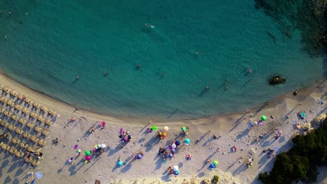 Aerial-drone-top-down-shot-over-tourists-enjoying-along-Punta-Molentis-Beach,-Villasimius,-South-Sardinia,-Italy-during-evening-time