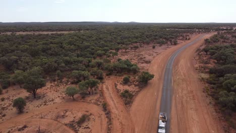 Aerial-view-of-a-country-road-in-the-Australian-Outback,-ute-and-trailer-passing-by