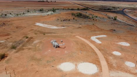 Vista-Aérea-De-Una-Estatua-De-Dinosaurio-En-Un-Parque-En-El-Interior-De-Australia