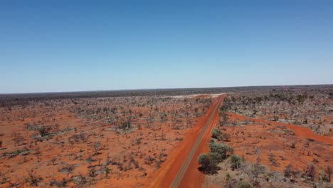 Drone-Volando-Hacia-Una-Carretera-Sellada-Y-Una-Intersección-De-Carreteras-Sin-Sellar-En-El-Interior-De-Australia