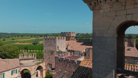 Luftaufnahme-Des-Französischen-Architektonischen-Schlosses,-Außenansicht,-Hügellandschaft-Im-Hintergrund-Im-Mittelalterlichen-Dorf