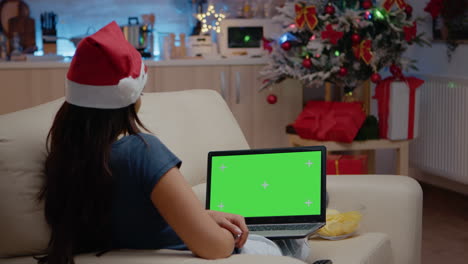 Woman-looking-at-horizontal-green-screen-on-laptop