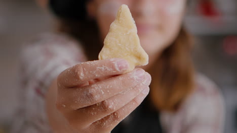 Selective-focus-of-child-holding-cookie-dough-with-tree-shape-in-hands