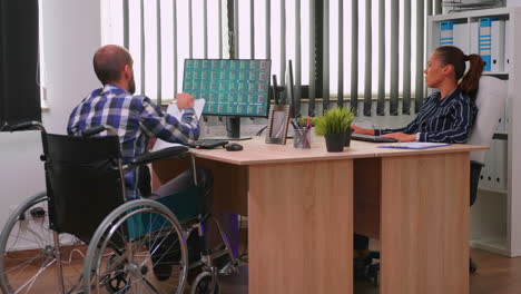 Paralysed-financial-expert-sitting-in-wheelchair-analysing-economy