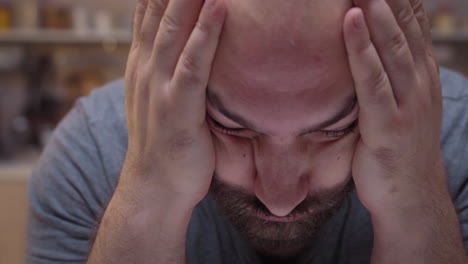 Man-with-headaches-sitting-in-the-kitchen