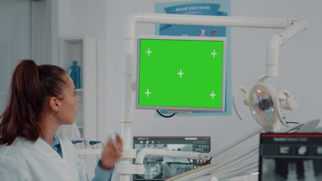 Nahaufnahme-Eines-Zahnarztes,-Der-Auf-Den-Monitor-Mit-Grünem-Bildschirm-Blickt