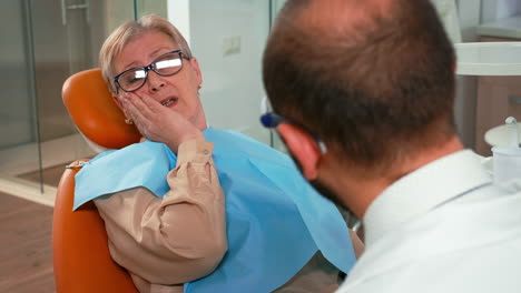 Client-touching-face-having-toothache-at-stomatology-clinic