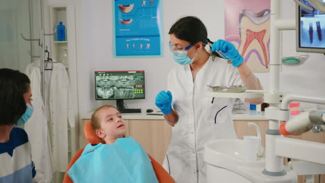 Dentista-Revisando-Con-Espejo-La-Salud-Dental-De-La-Niña-Paciente