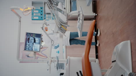 Vertical-video:-Woman-dentist-preparing-stomatology-chair