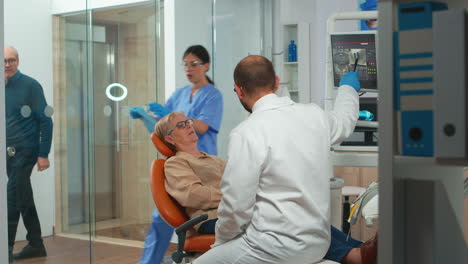 Estomatólogo-Apuntando-A-La-Pantalla-Digital-Explicando-La-Radiografía
