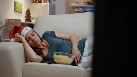 Adult-with-santa-hat-sleeping-on-couch-at-television