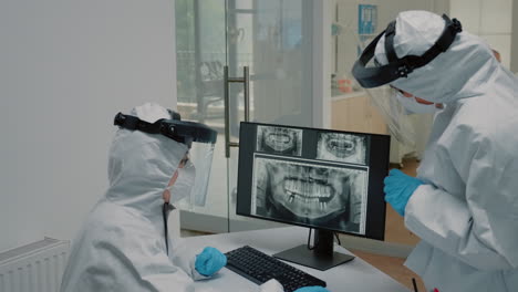 Dentistry-staff-looking-at-dental-x-ray-scan-wearing-ppe-suits