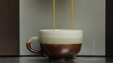 Espresso-Shot-Strömt-Aus-Der-Kaffeemaschine-In-Einer-Kleinen-Weißen-Und-Braunen-Tasse.-Nahaufnahmen