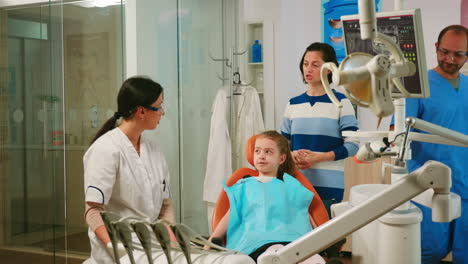 Dentista-Pediátrico-Explicando-Al-Niño-El-Proceso-De-Limpieza-De-Los-Dientes