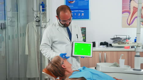 Zahnarzt-Schaut-Auf-Greenscreen-Tablet