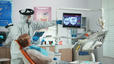 Zahnarzt-Mit-Gesichtsschutz,-Der-Das-Panorama-Röntgenbild-Des-Mundes-überprüft