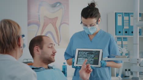 Nurse-and-patient-analyzing-denture-radiography-in-dentistry-cabinet