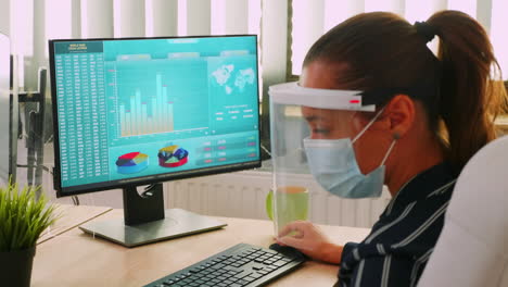 Woman-with-mask-working-on-laptop-during-coronavirus-pandemic