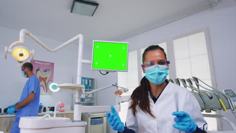 Punto-De-Vista-Del-Paciente-Del-Dentista-Explicando-El-Problema-Usando-Un-Monitor-De-Pantalla-Verde