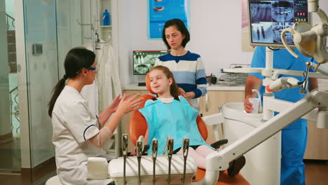 Stomatologe-Erklärt-Kleinem-Mädchen-Den-Reinigungsprozess-Der-Zähne