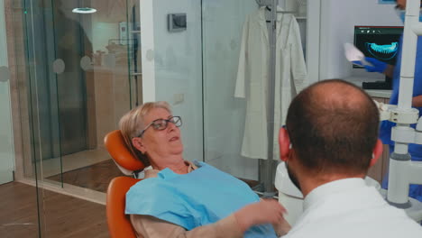 Frau-Mit-Neuen-Zahnimplantaten-Schaut-In-Den-Spiegel