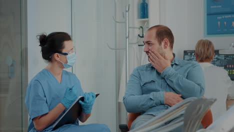 Paciente-Explicando-El-Dolor-De-Muelas-A-La-Enfermera-De-Odontología-En-La-Visita-De-Estomatología.