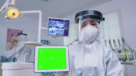 Patient-pov-of-dentist-in-ppe-suit-pointing-on-green-screen