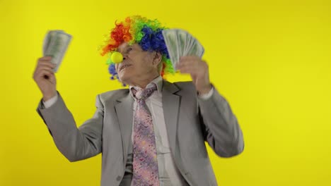 Elderly-clown-businessman-entrepreneur-boss-dancing-with-money-cash-banknotes