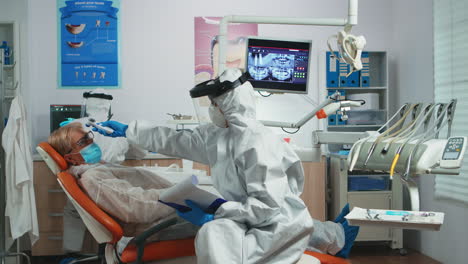 Dentist-nurse-in-potective-suit-controlling-patient-temperature