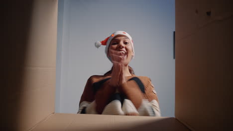 Caucasian-woman-with-santa-hat-opening-present-box
